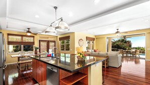A spacious kitchen with a central island, wooden cabinets, and a dining area with a table and chairs.