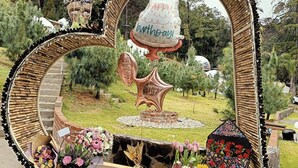 A heart-shaped mirror with a birthday cake and flowers.
