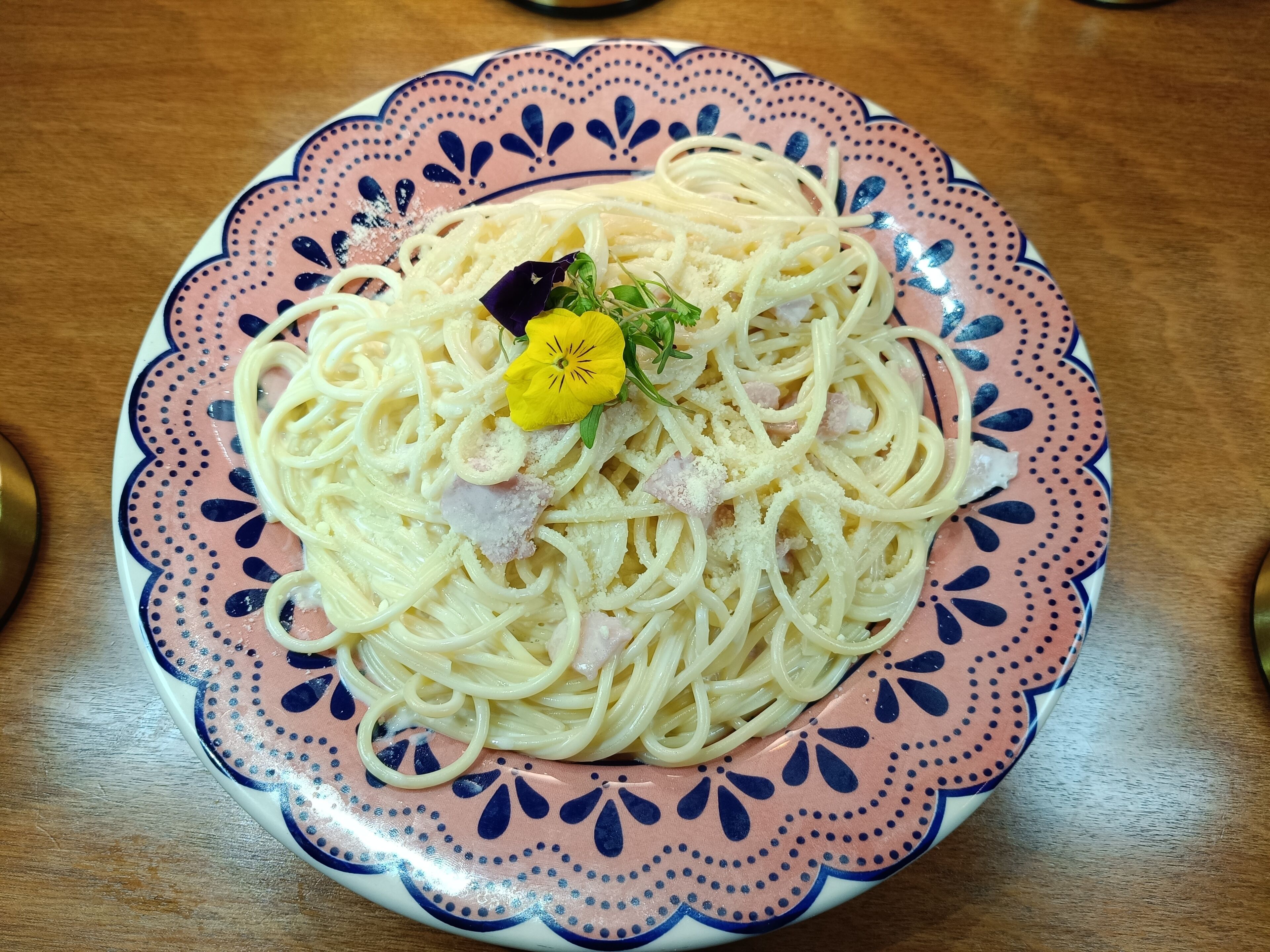 Un plato de espagueti con adornos sobre un plato decorativo.