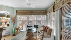 A dining area with a round table, chairs, and a ceiling fan. - Near Pool, Playground, Walk to Beach (Miramar Beach)