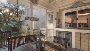 A wooden deck with a round table and chairs, a hanging lantern, and a welcome sign. - Near Pool, Playground, Walk to Beach (Miramar Beach)