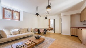 Un salon moderne avec un canapé, une table basse et un coin repas.