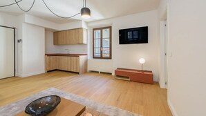 Une cuisine moderne avec des meubles en bois, un four encastré et une grande fenêtre.