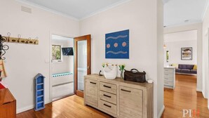 Una habitación con un armario de madera, un tapiz azul y una puerta que da a otra estancia.