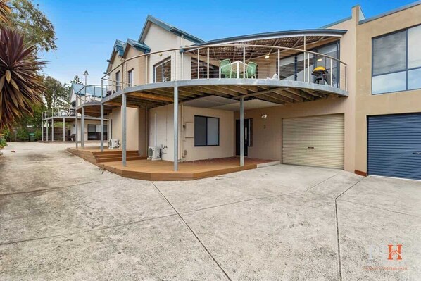A two-story house with a covered patio and a garage.