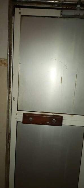 Eine Tür mit Metallbeschlag und Holzverkleidung.