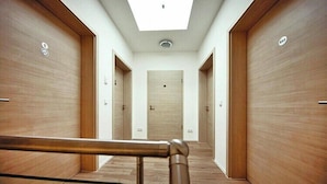 A hallway with wooden doors, a skylight, and a metal handrail. - Appartement in Strausberg (Strausberg)