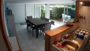 Una cocina con comedor, estufa y lavaplatos.