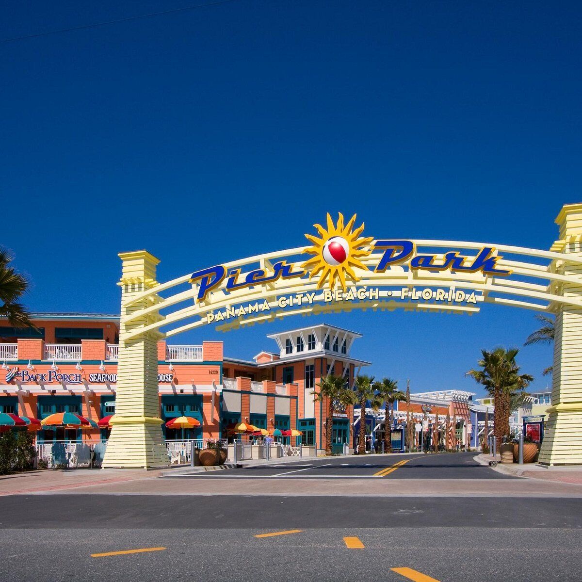 De ingang van Pier 70 Park, Panama City Beach, Florida, met een opvallend bord met een zon en palmbomen.