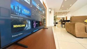 A modern living area with a large flat-screen TV displaying a video player interface. - FUN GAME St. Julians Apartment 3 (San Ġiljan)