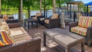 Eine Terrasse im Freien mit Korbmöbeln und einer Pergola.