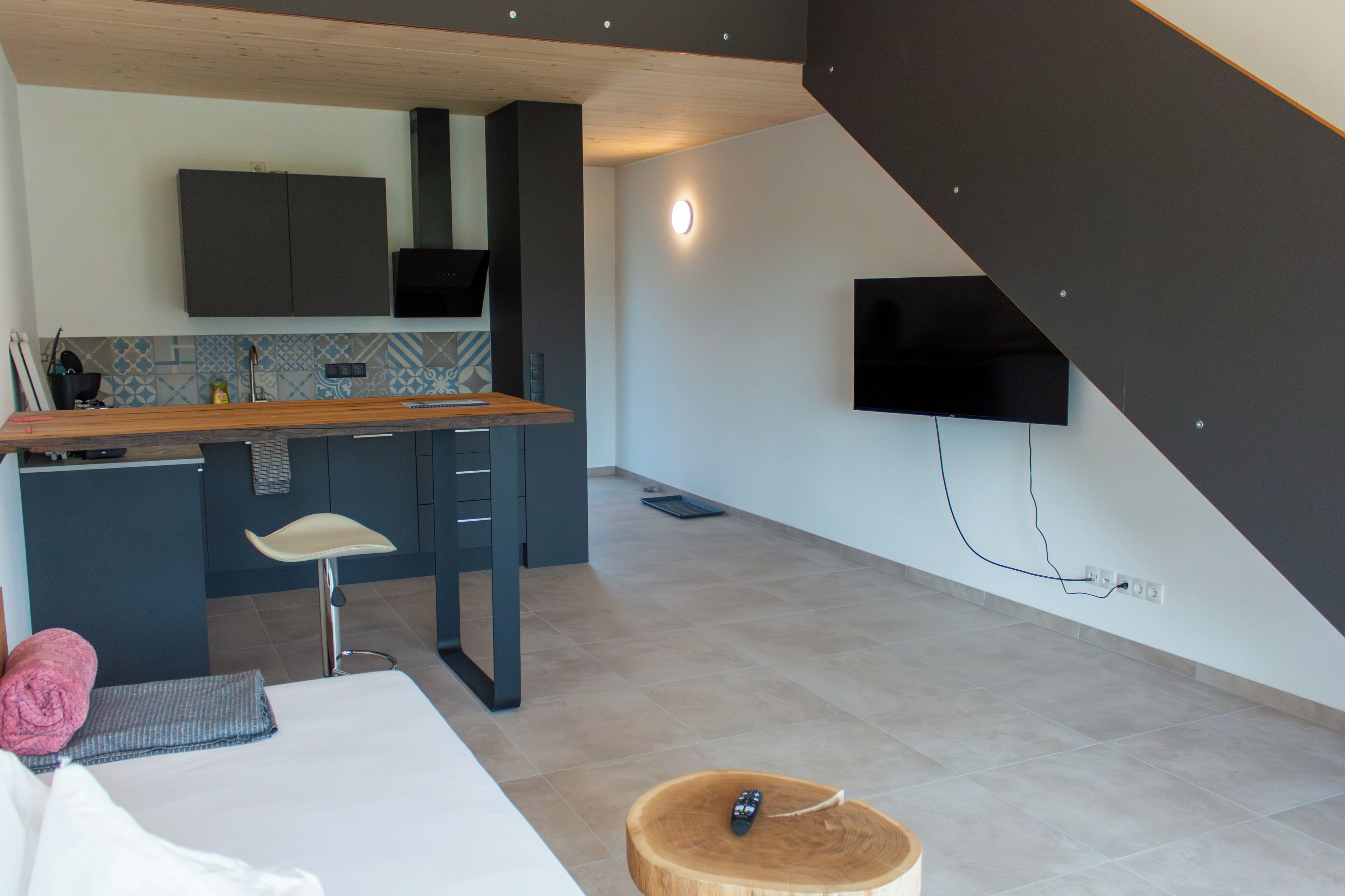 Een moderne keuken met een inbouwkoelkast, een bar en een flatscreen televisie aan de muur.