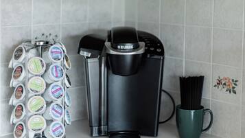 A coffee maker, a mug, and a coffee pod holder on a kitchen counter.