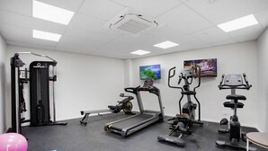A gym with treadmills, elliptical machines, and a weight machine. - Augustus Hideaway Studio Apt with Air-Con (Auckland Central Suburbs)