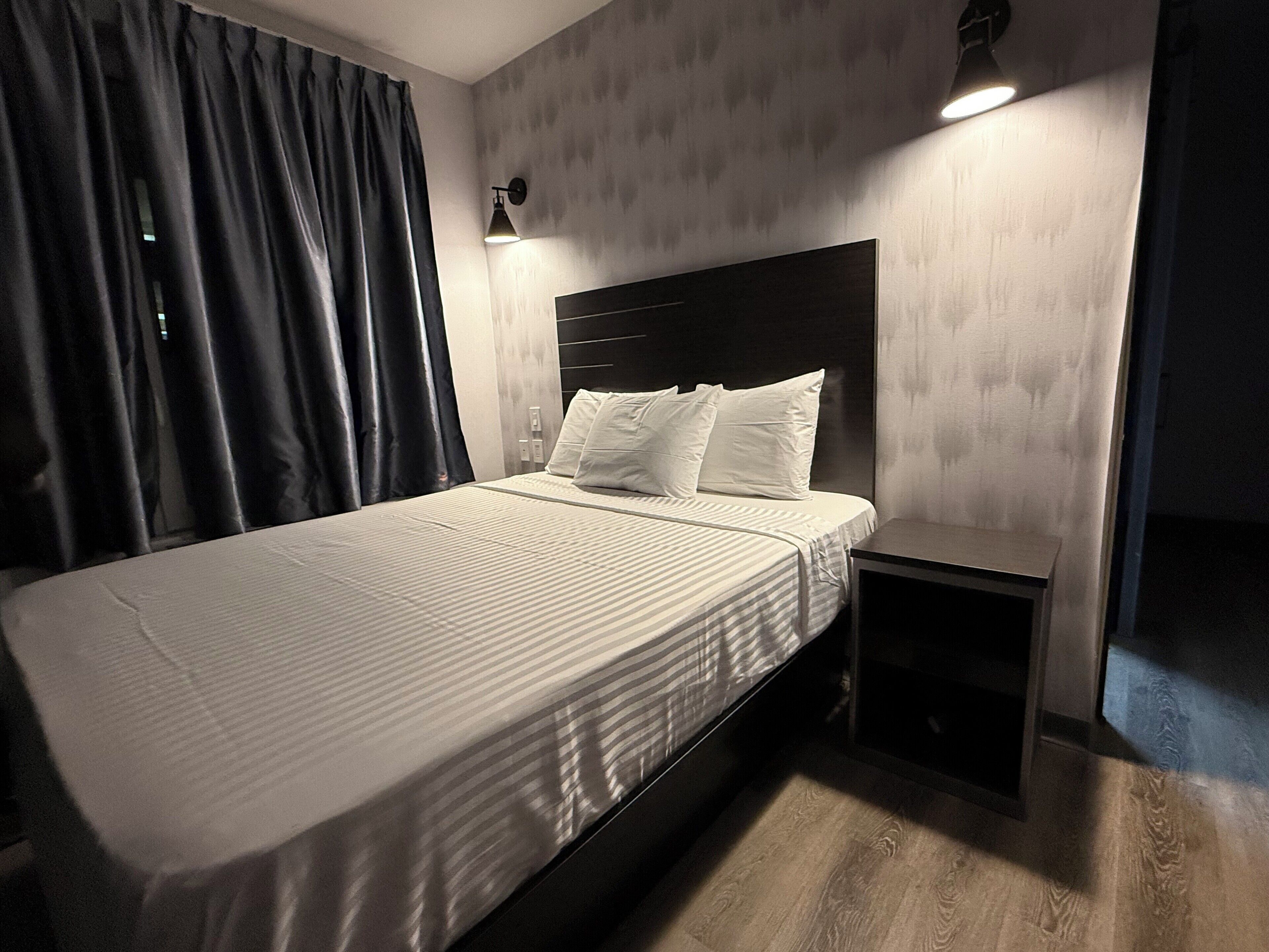 A modern bedroom with a bed, bedside tables, and a nightstand.