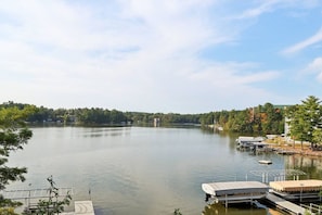 A calm lake with docked boats, surrounded by trees and buildings.