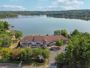 A multi-story hotel with a central courtyard, surrounded by trees and a large body of water. - Beachview Twin #1 at Delton Grand (428) (Wisconsin Dells)
