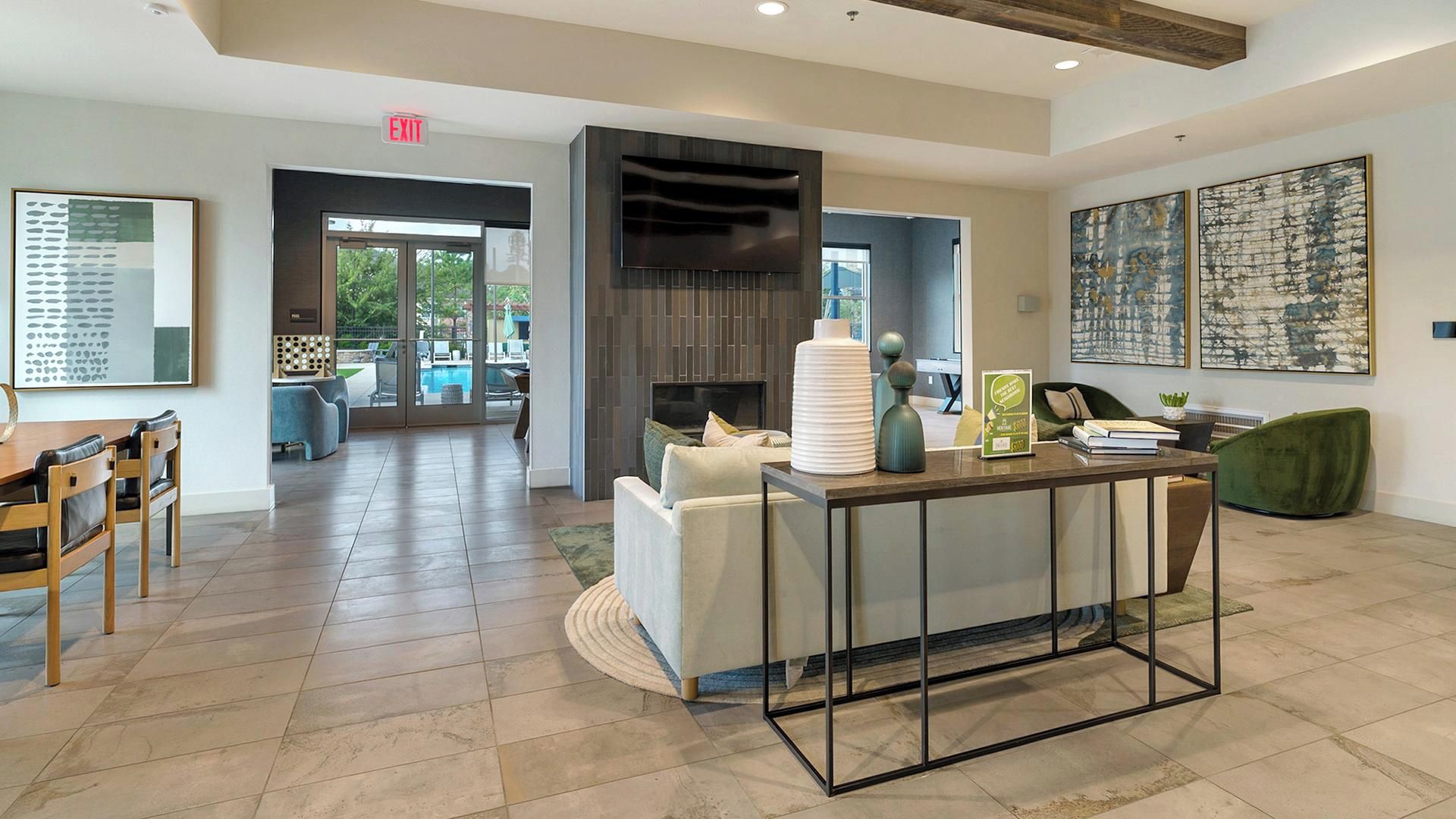 A spacious lobby with a reception desk, seating area, and a view of the outdoor pool.