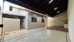A spacious indoor area with tiled floors, a high ceiling, and two air conditioning units on the walls. - Complete House Near the Airport (Jardim Petropolis Campo Grande)