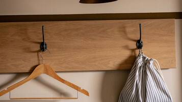 Pared de madera con un perchero de madera y un bolso a rayas.