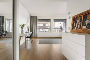 Sala de estar moderna com área de jantar, janelas amplas e vista para a cidade.