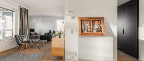 A modern living room with a dining area, a wooden cabinet, and a painting on the wall.
