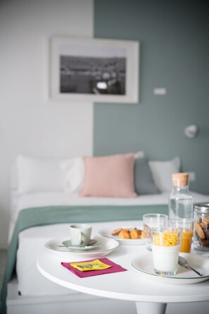 A neatly arranged breakfast table with a plate of pastries, a glass of orange juice, and a bottle of milk.