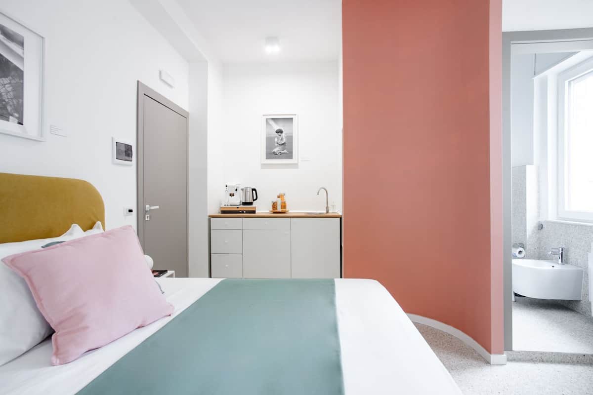 Una habitación de hotel moderna con cama, kitchenette y baño.