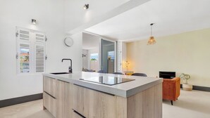 Una cocina moderna con una isla central, un lavamanos integrado y un espejo grande encima de la isla.