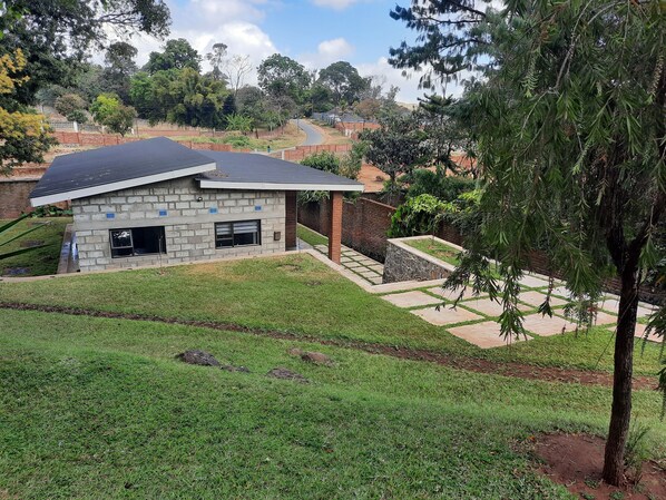 A modern house with a stone facade, a garage, and a covered patio area.