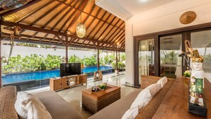 A spacious living area with a pool, comfortable seating, and a statue. - Villa Panda Seminyak Next to KU DE TA (Seminyak)