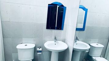 Ein Badezimmer mit Toilette, Waschbecken und Spiegel.