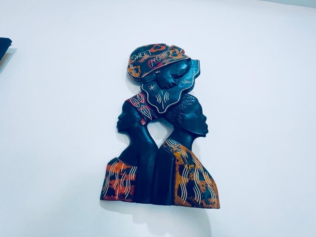 A sculpture of a woman with a patterned headscarf and a patterned dress.