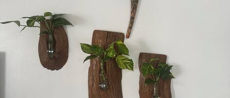Three wooden planters with plants on a white wall.