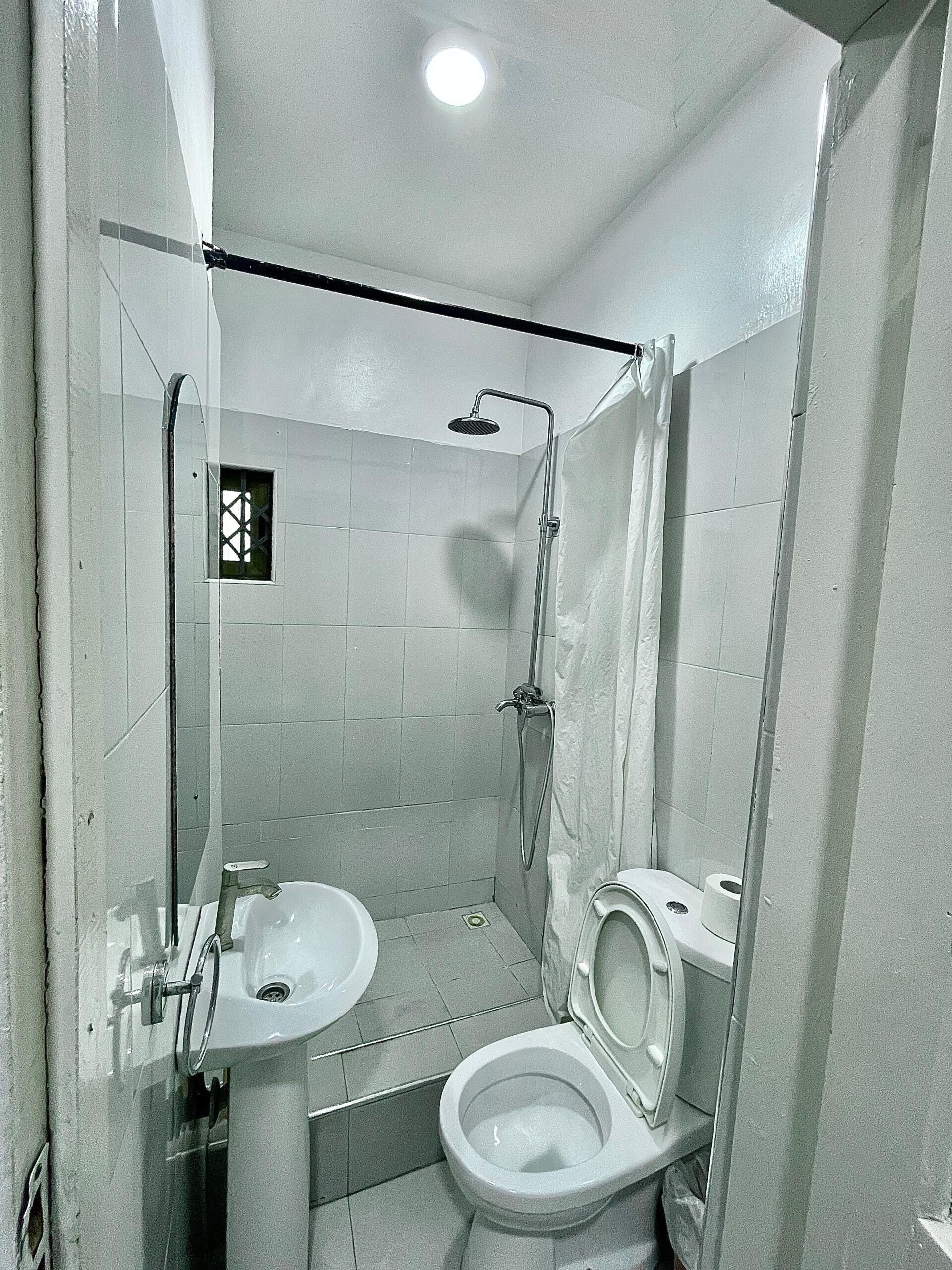 Ein kleines, kompaktes Badezimmer mit Dusche, Toilette und Waschbecken.