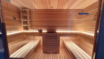A sauna with wooden benches and a central heating element.