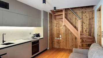 Una cucina moderna con una scala in legno e un divano.
