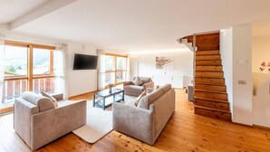 Una sala de estar moderna con un conjunto de sofá, una mesa de centro y una escalera.