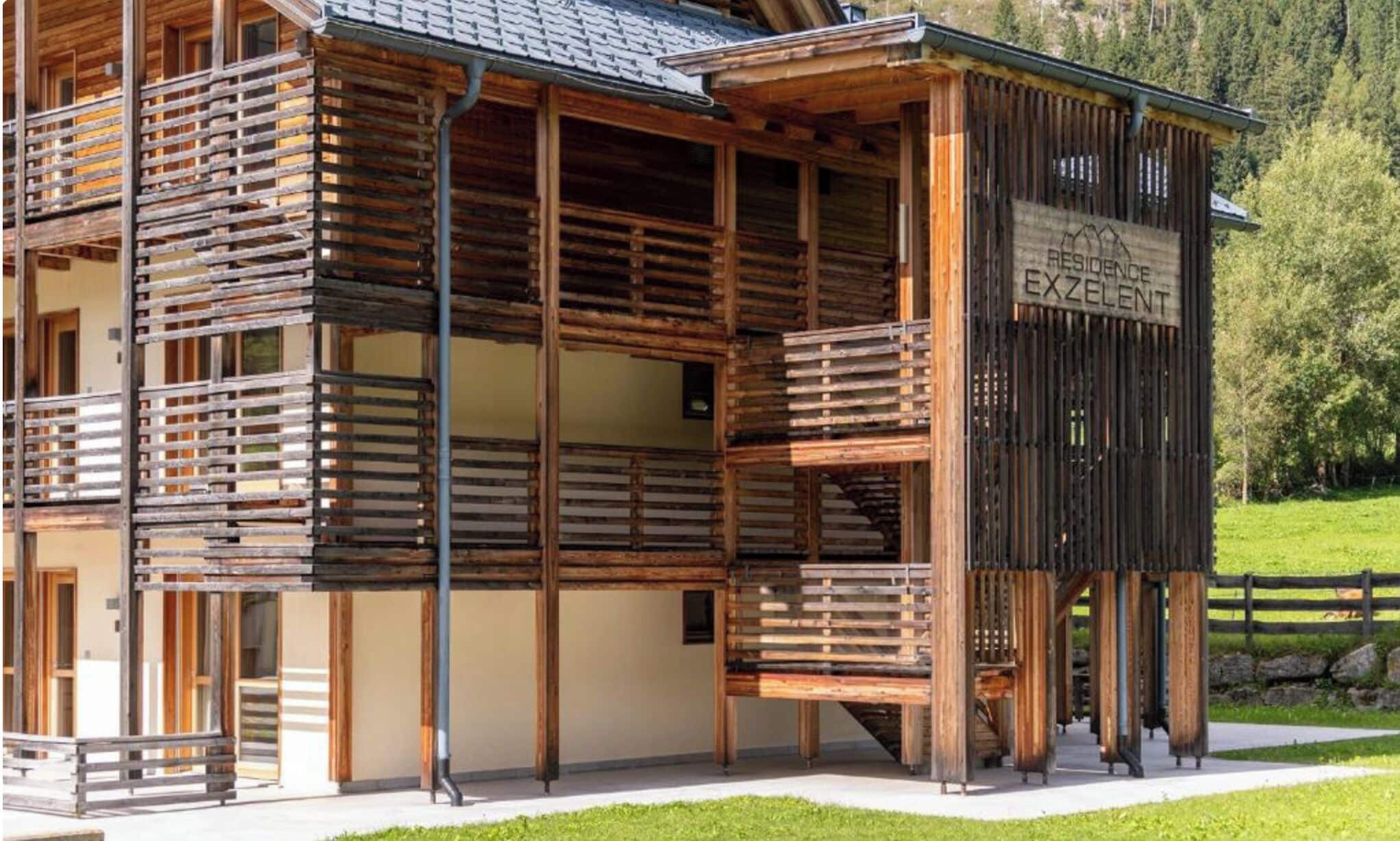 A wooden building with a balcony and a sign that reads 'RESIDENCE EXCELENT.'