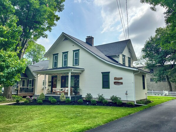 A two-story house with a porch, a front yard, and a driveway.