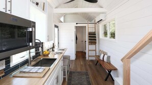 Une cuisine moderne équipée d’une cuisinière intégrée, d’un four à micro-ondes et d’une grande fenêtre.