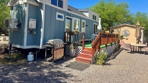 Une péniche dotée d’une terrasse, de sièges extérieurs et d’un barbecue.