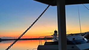 Un bateau était amarré dans une marina, d’où l’on pouvait admirer le coucher de soleil sur l’eau.