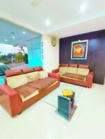 A modern living room with two red sofas and a glass coffee table.