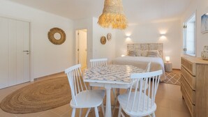 A bedroom with a bed, bedside table, and a hanging light fixture. - 31-Basement apartment - Villa Natura Bliss (Alcácer do Sal)