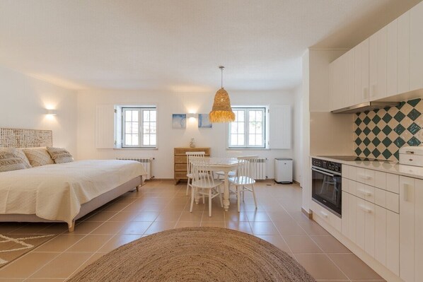 A bedroom with a bed, bedside table, and a window.