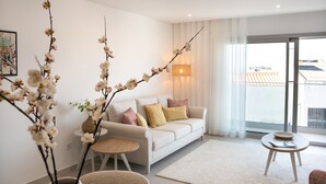 Un salon moderne avec un canapé, une table basse et un vase rempli de fleurs.