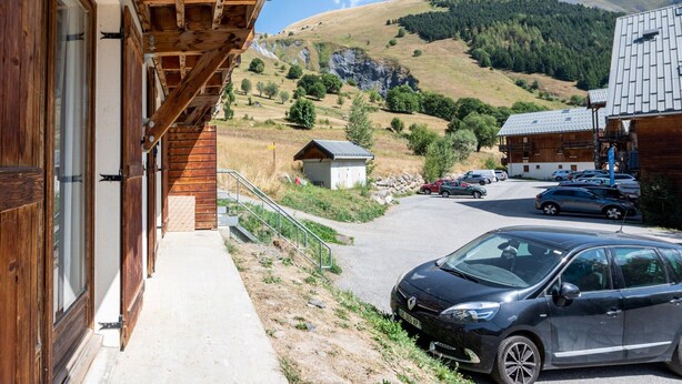 Ein Holzhaus mit einem geparkten Auto davor.