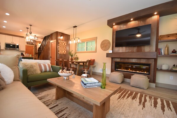 TV connectée, cheminée, livres, chaîne hi-fi