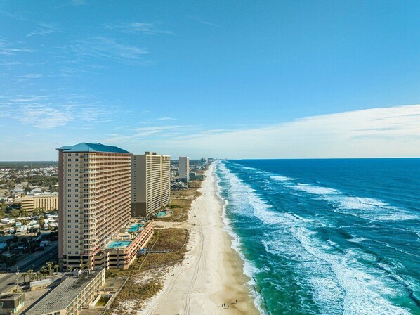A coastal hotel with multiple high-rise buildings, a beach, and ocean views.